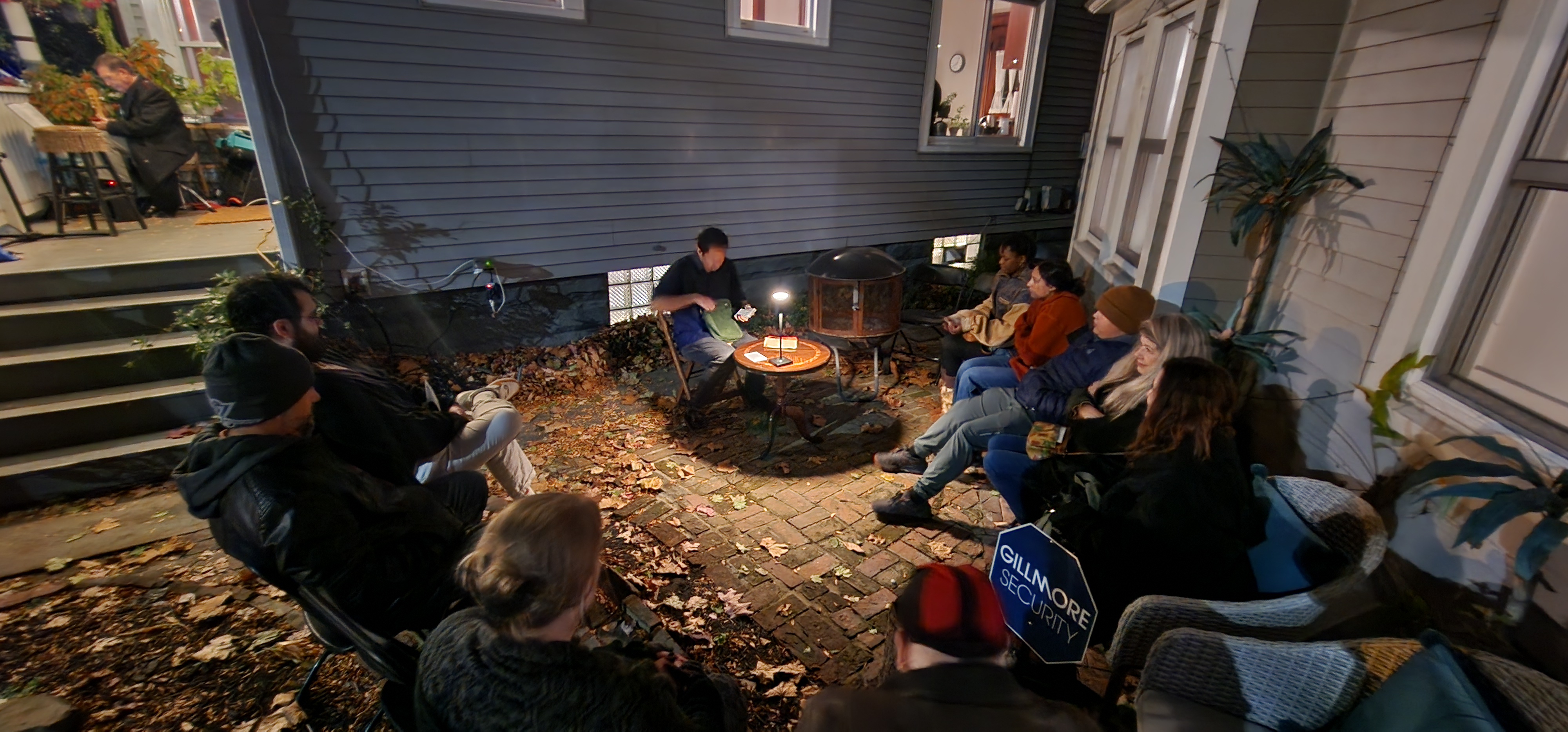 Intimate circle of audience in a backyard patio at night